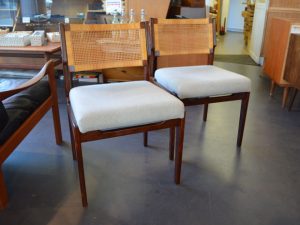 Zwei Stühle mit geflochtener Lehne und hellgrauem Bezug